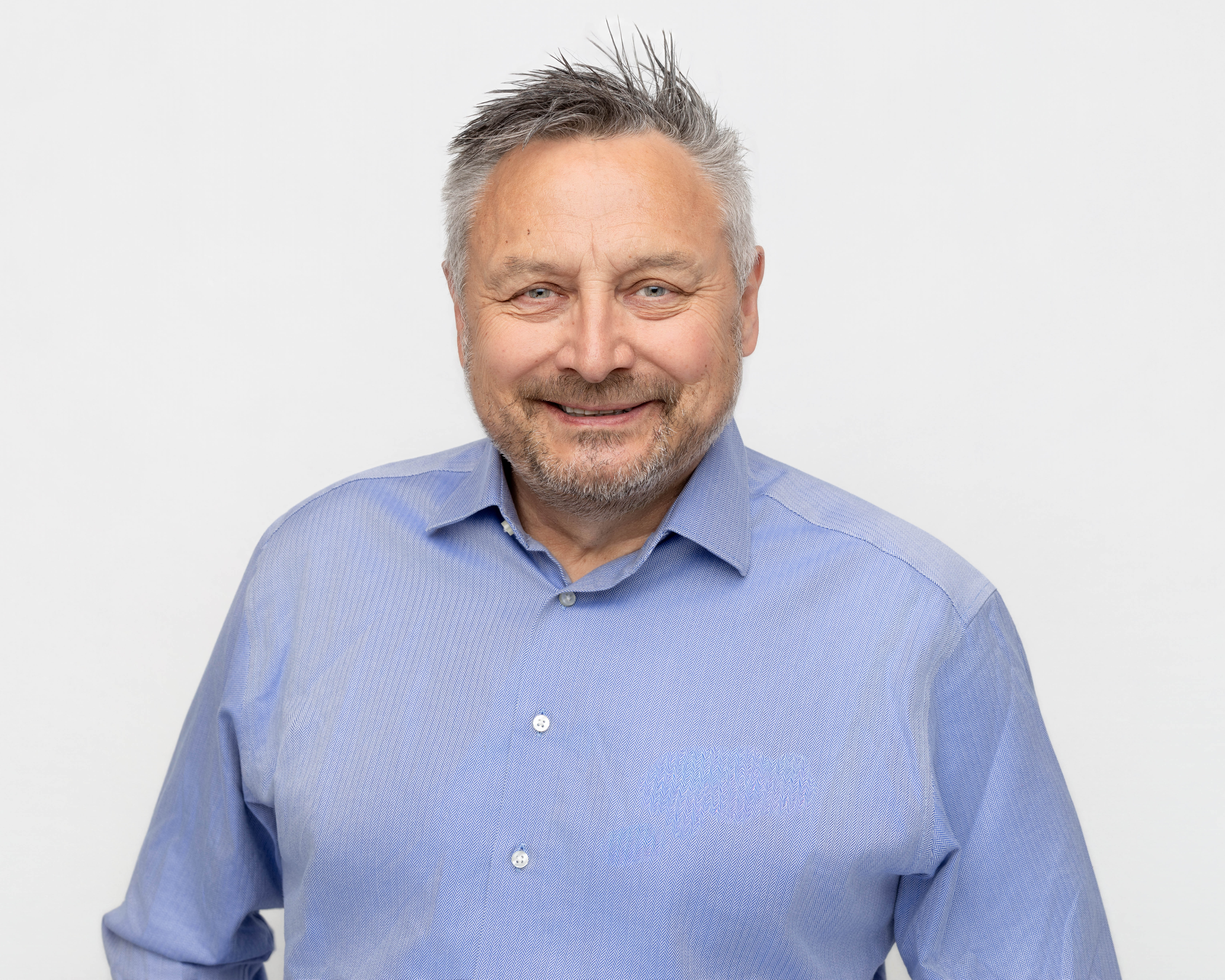 Smilende mann i blå skjorte