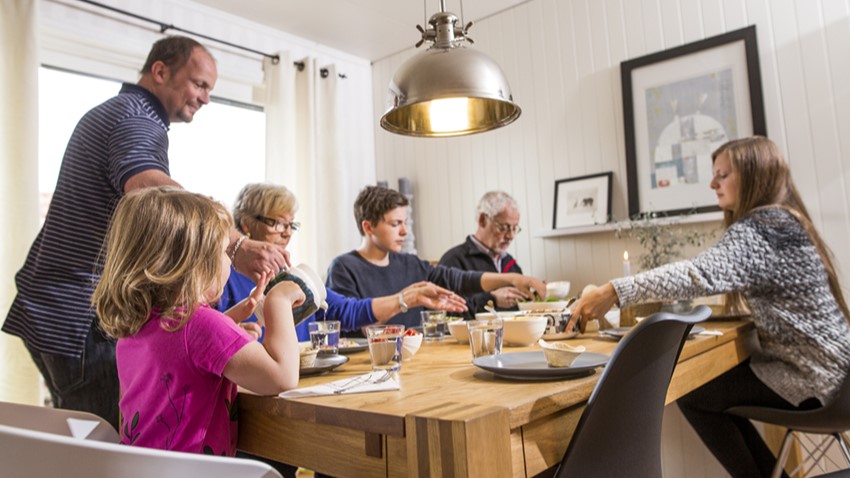Foto: Husbanken/Ricardofoto. Seks personer i forskjellig alder samlet rundt middagsbord.