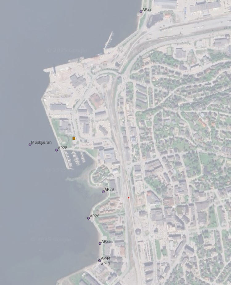 Omsøkte utslippsunkter ved ombygging av Moskjæran renseanlegg er markert med lille prikk. Moskjæran renseanlegg er markert med brun firkant. Satelittfoto som viser sjøområde og landområde med bebyggelse. Langs sjøkanten er det lagt inn flere prikker.