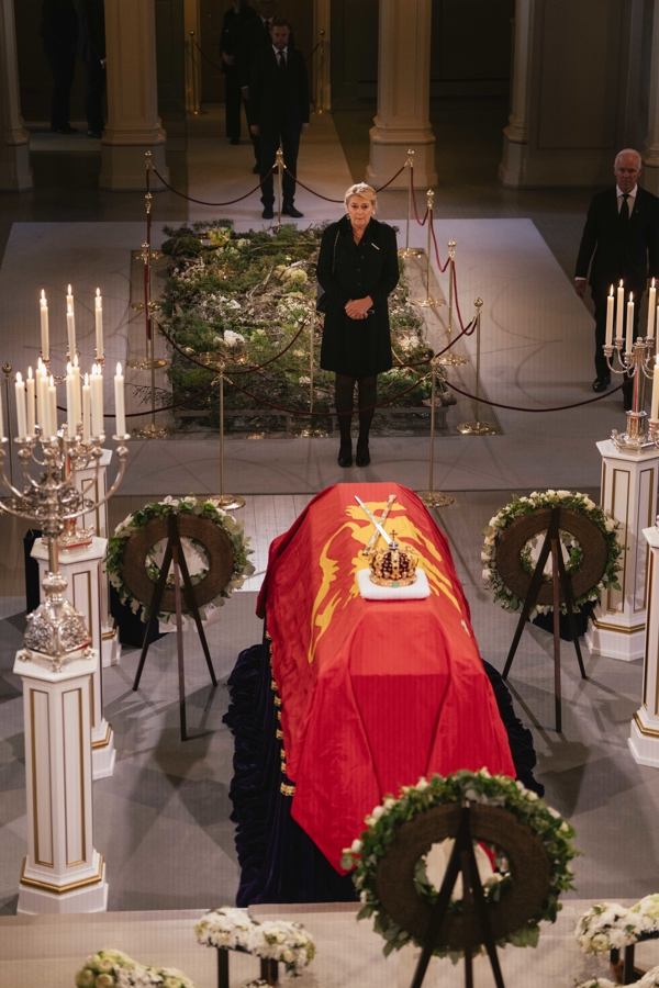Statsforvalter Gina Lund under defileringen ved Kong Harald Vs båre i Slottskapellet. Båren er omgitt av lys og kranser under den nasjonale markeringen i forbindelse med gravferden.