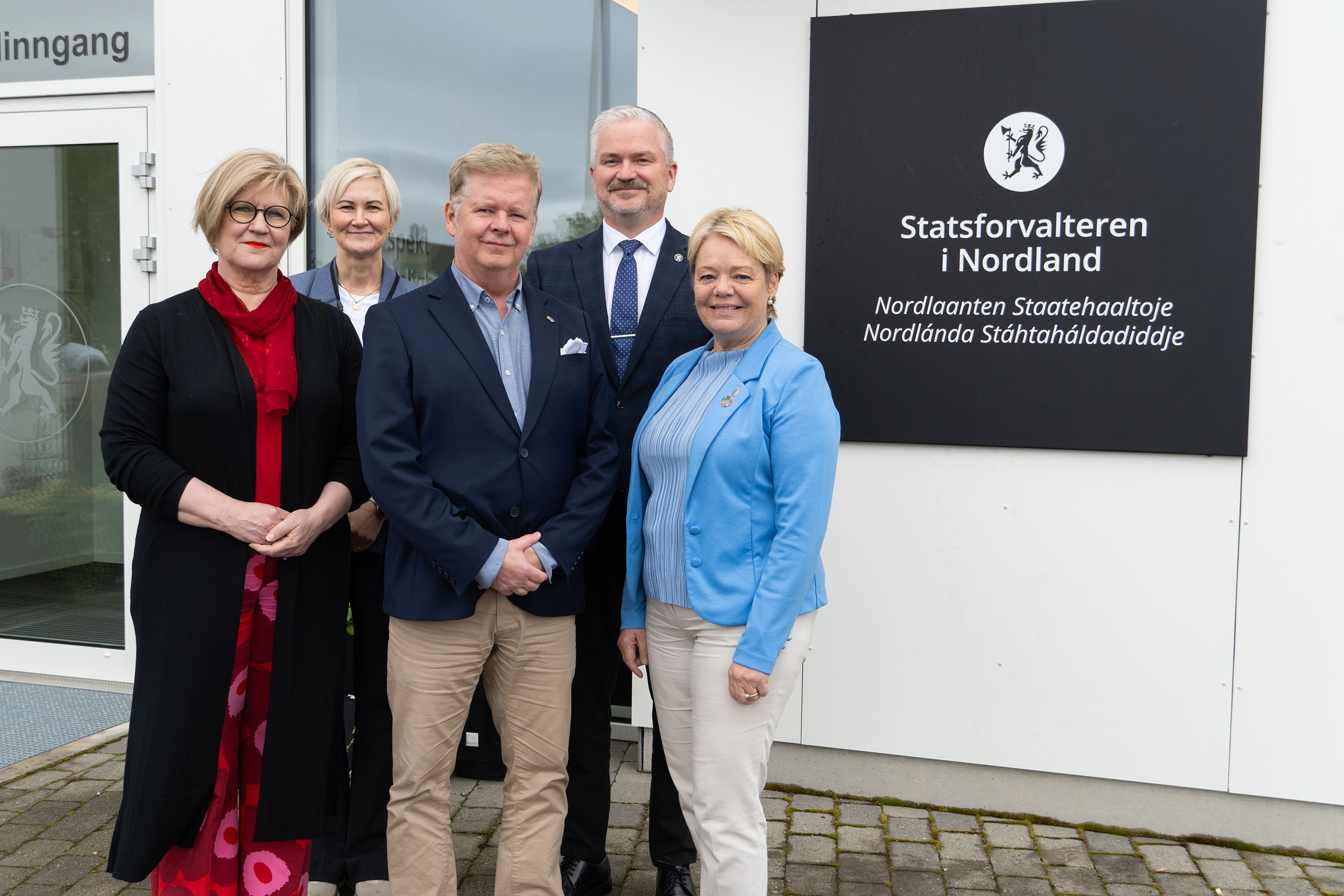 Kristiina Poikajärvi (överdirektør i Lappland), Toril Feldt (statsforvalter i Troms og Finnmark), Lars Lustig (länsråd i Västerbotten), Tom Cato Karlsen (statsforvalter i Nordland), Lotta Finstorp (landshövding i Norrbotten). Foto: Emil Harjo Indsetviken / Statsforvalteren i Nordland. Fem personer står oppstilt foran inngangen til en kontorbygning.