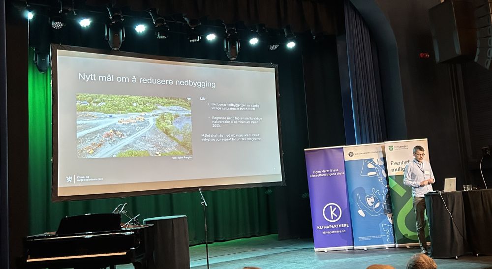 Mann på scene som holder en presentasjon