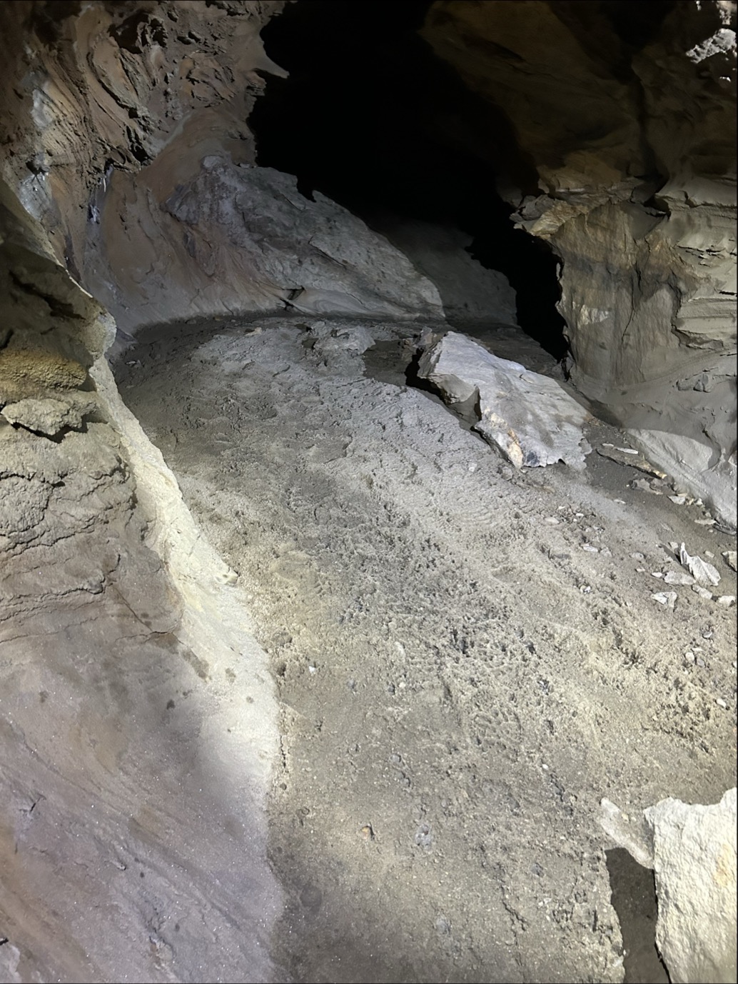 Fotspor i sediment som ligg inne i ei grotte