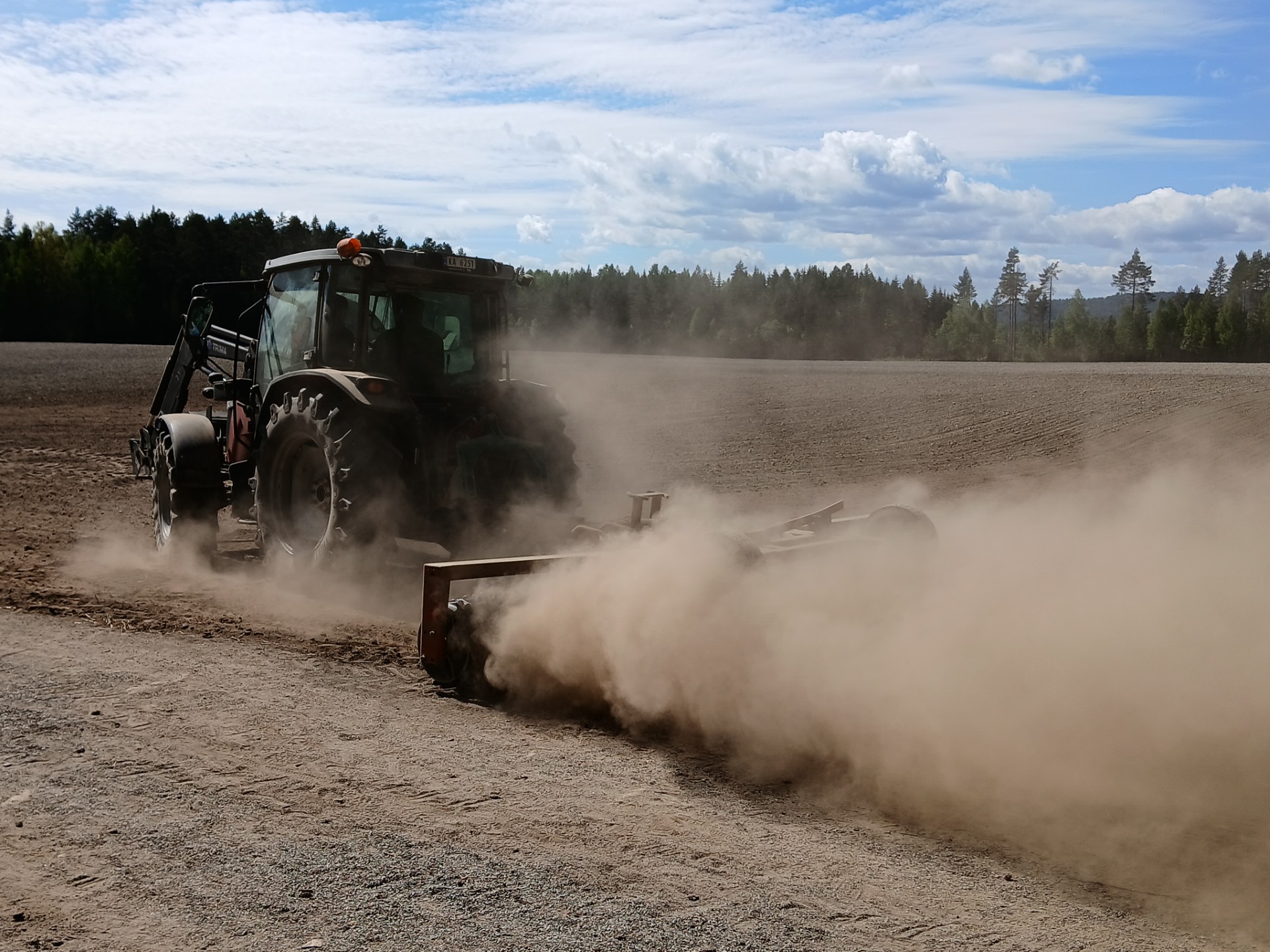 traktor med slådd på jordet 