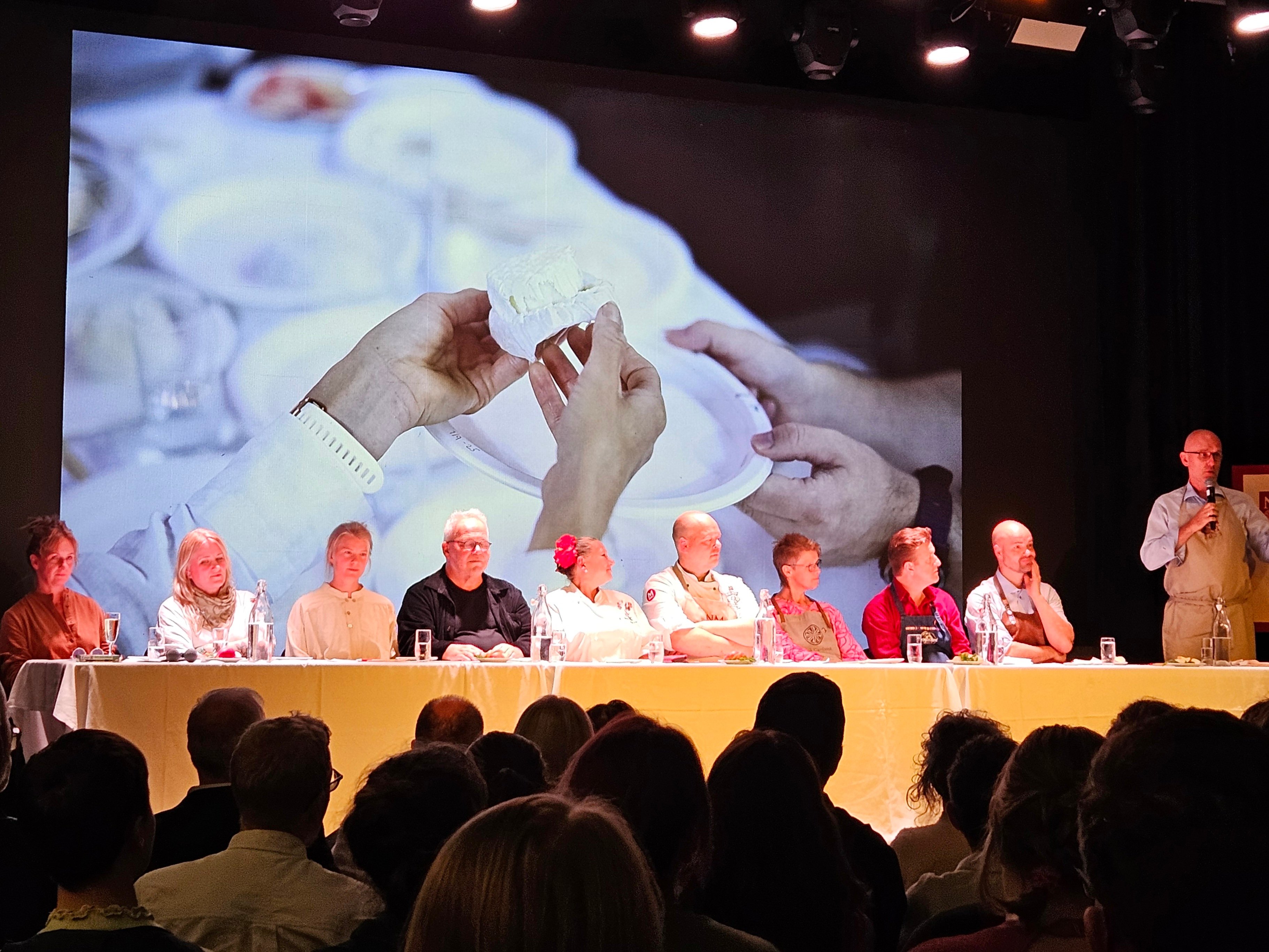 En bredt sammensatt finalejury bedømte de ti beste ostene 2025 med publikum i salen. Foto: Statsforvalteren. Panel med dommere på Norgesmesterskap i ost 2025