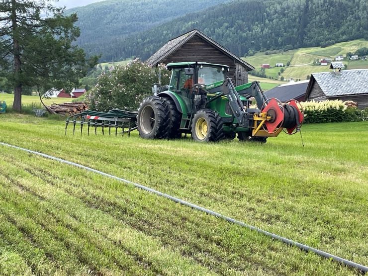 Traktor med utstyr for nedlegging av husdyrgjødsel med tilførselsslange