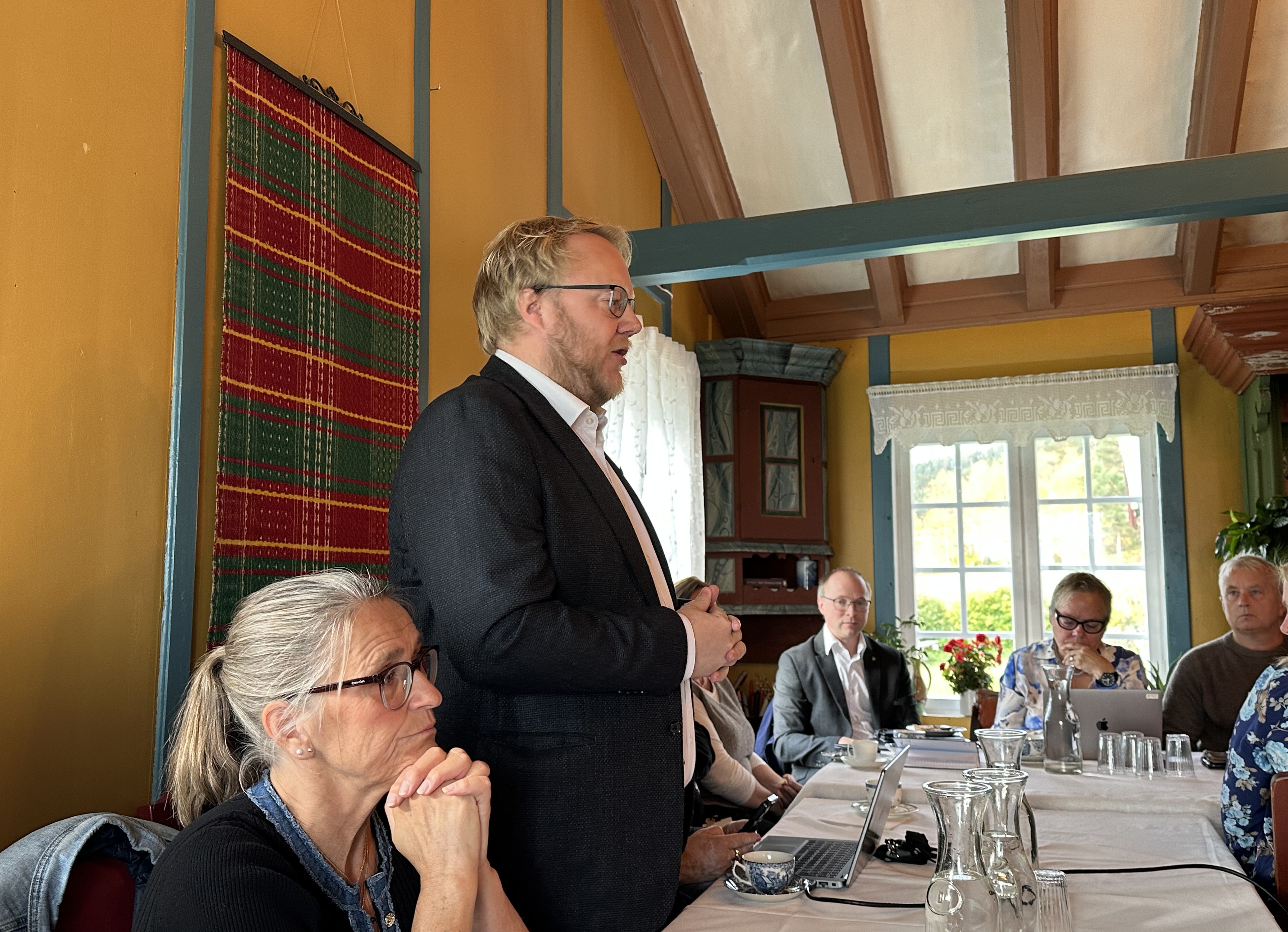 Bilde av regionrådsleder Bjørnar T. Jordet som snakker på møte i en stue på Storeggen gard.
