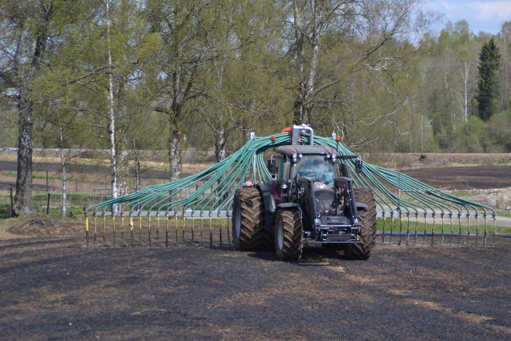 Husdyrgjødselspredning ved nedlegging og bruk av tilførselsslange er et godt klimatiltak. Foto: Karoline Finstad Vold. Traktor på jorde med påmontert utstyr for nedlegging av bløt husdyrgjødsel