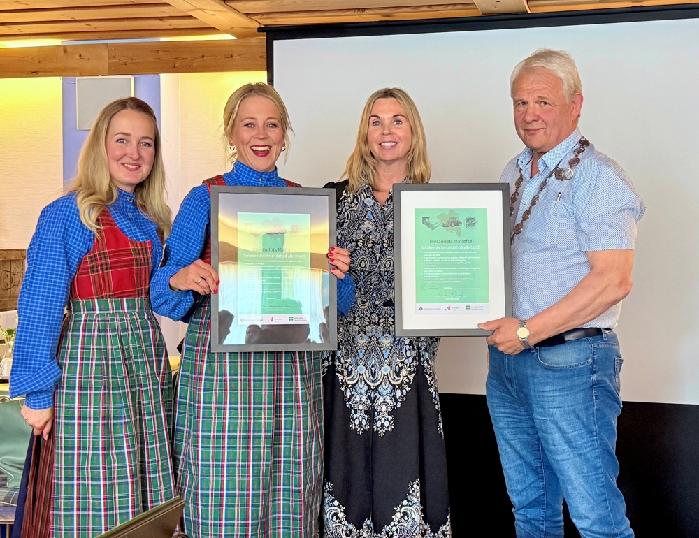 Fire personer viser fram to signerte matløfter som er ramma inn