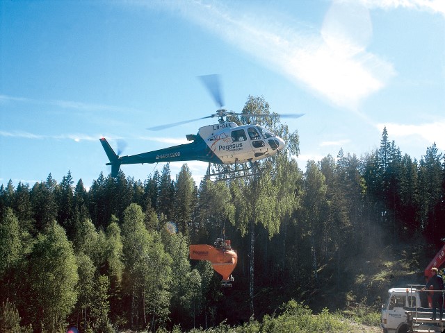 Helikoptergjødsling av skog. Foto: Anne Mæhlum. Foto av helikopter som bidrar til gjødsling av skog.